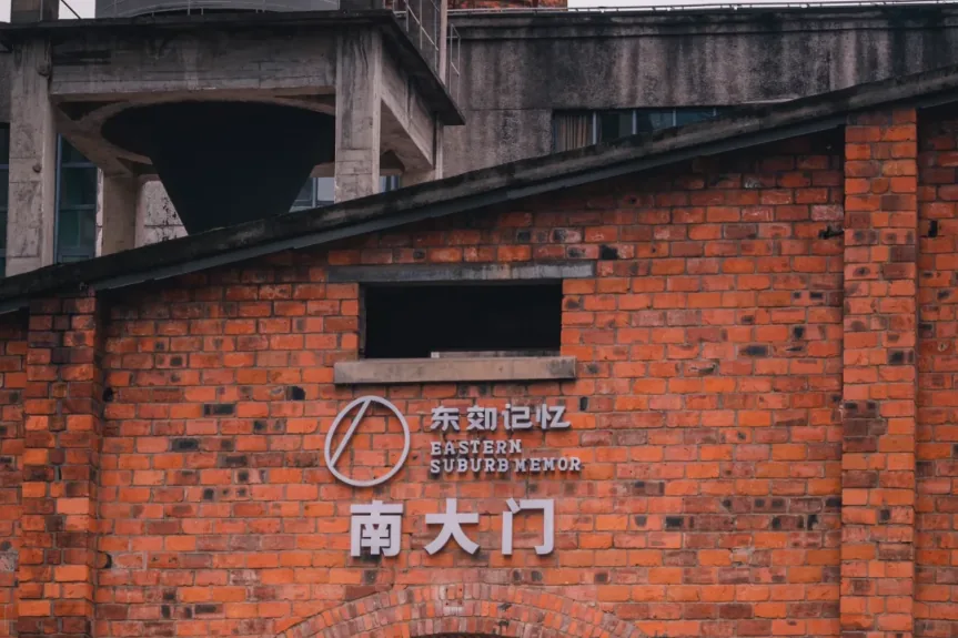 Red brick factory building with exposed metal pipes in Dongjiao Memory at dusk