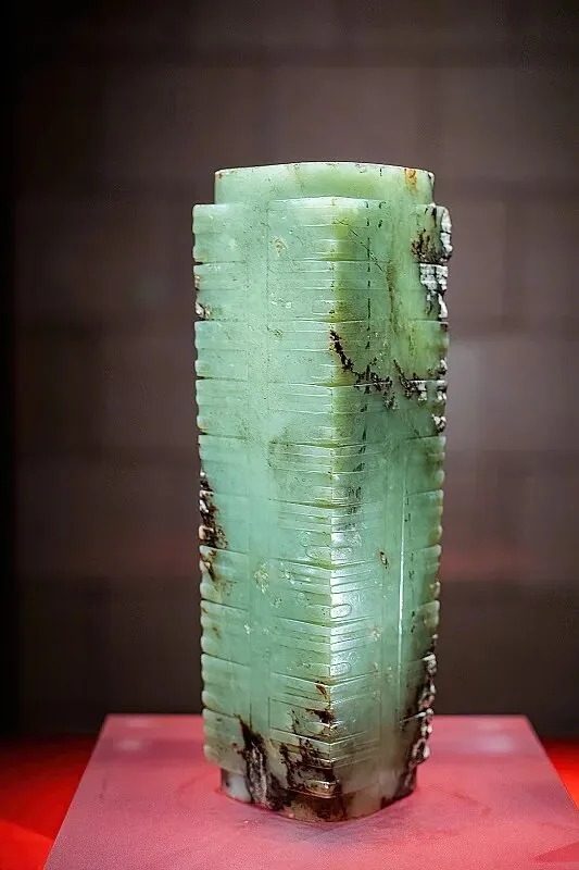 The green ten-section jade cong with intricate carved symbols