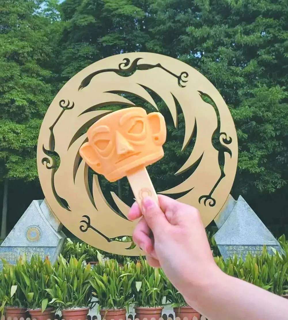 Gold mask shaped ice cream with mango and milk flavors on a stick