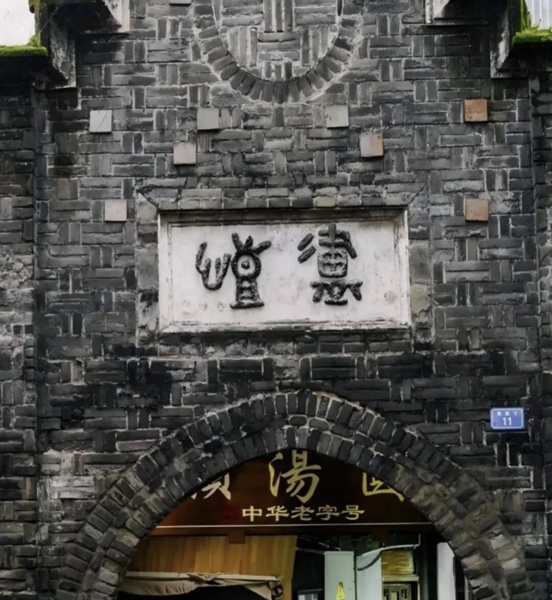 The iconic arched gate of Kailu at Kuanzhai Alley with mossy bricks and seal script