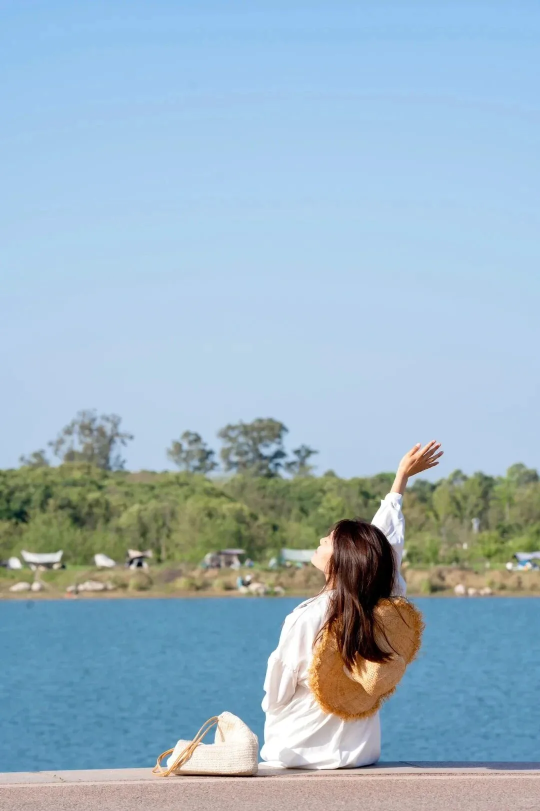 Wide lawn and calm lake at Qinglong Lake Wetland Park in Chengdu