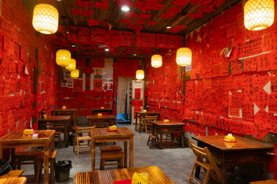 Owner with big wok and chalkboard menu at Mao Kaoya joint in Chengdu counting streets