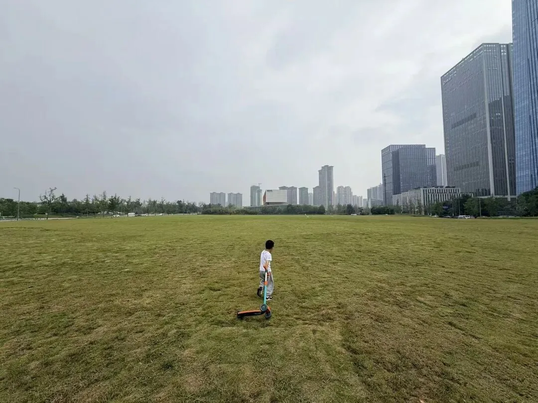 Lawns and distant slopes in Tianfu Park under autumn sun