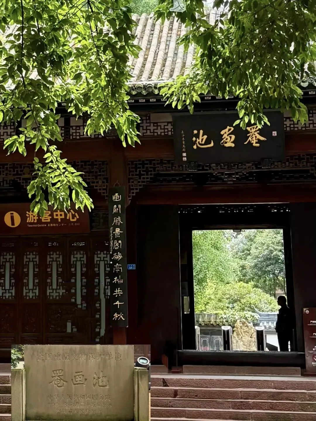 Red wall peeking through osmanthus blossoms at Lu You Shrine in Yihua Chi