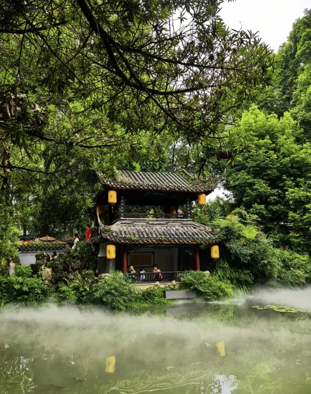 Three-fold covered bridge over Yihua Chi pond with koi and tea seats