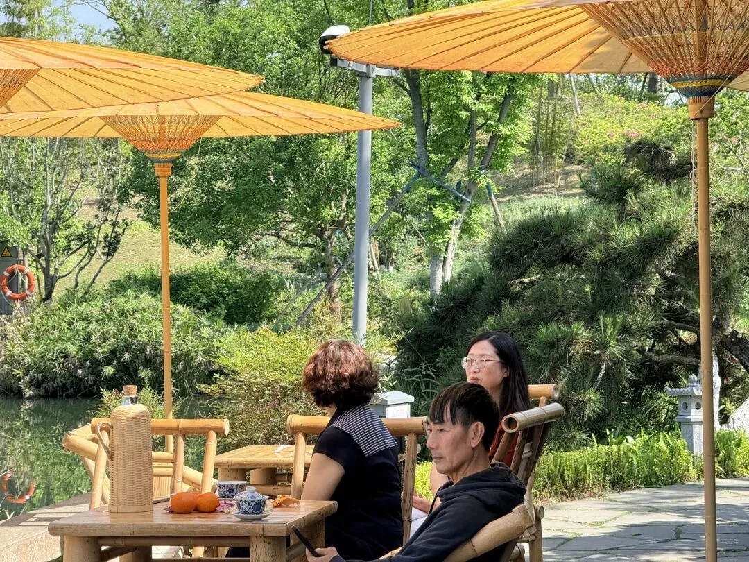 Bamboo tea tables by the lake at Shuyun Garden with Ziyun Pavilion view