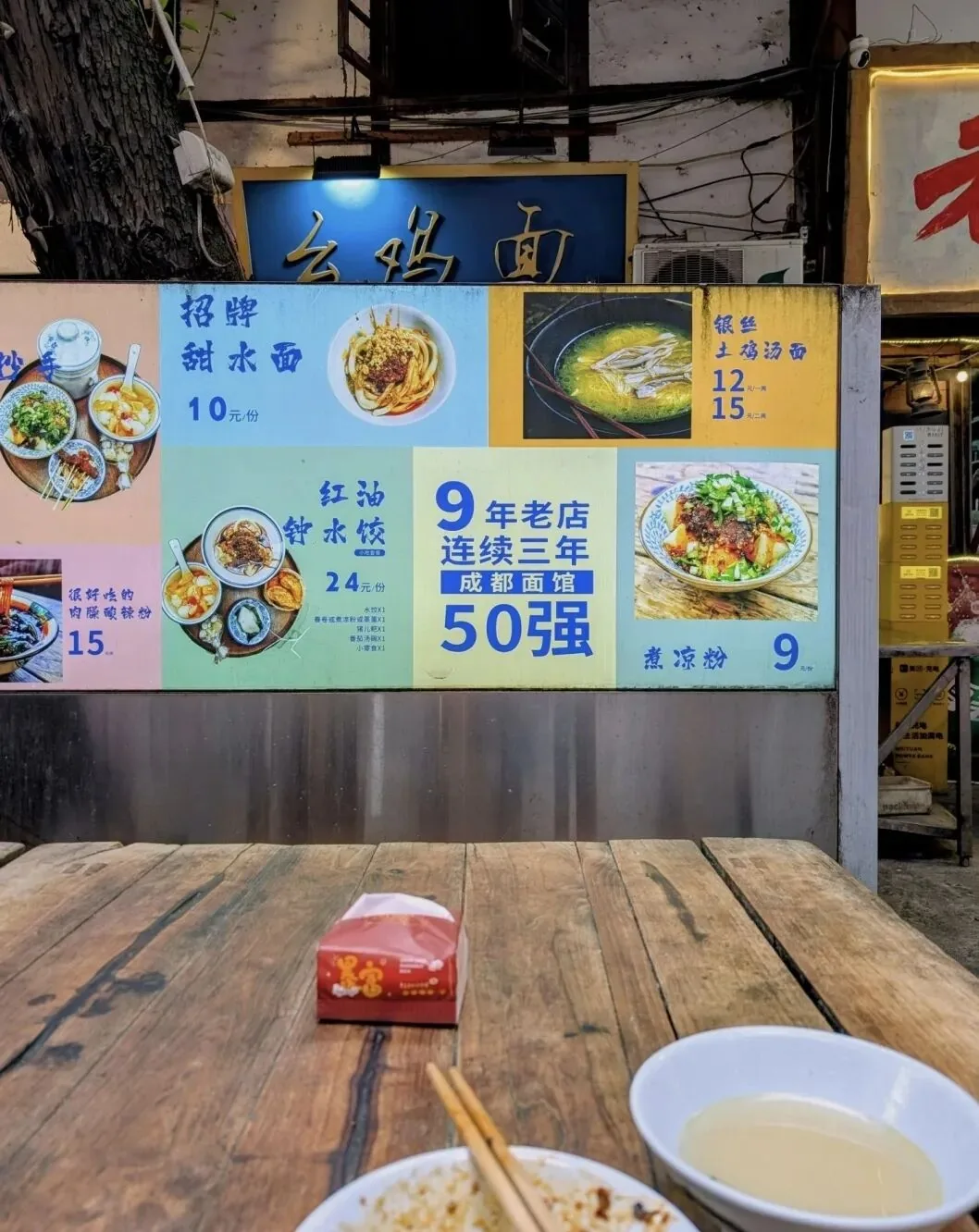 Narrow community alley in Chengdu filled with small food stalls and stools