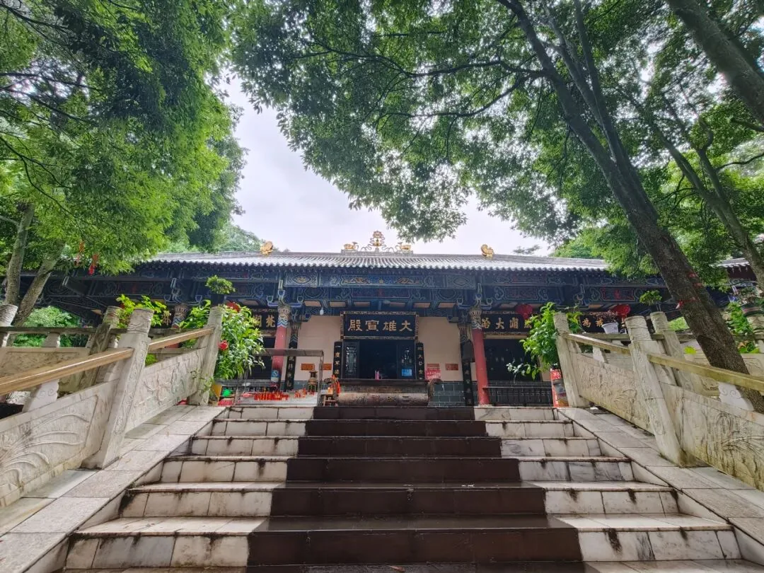 Golden arhat statues lining the stone path at Lower Sanmei Anguo Temple