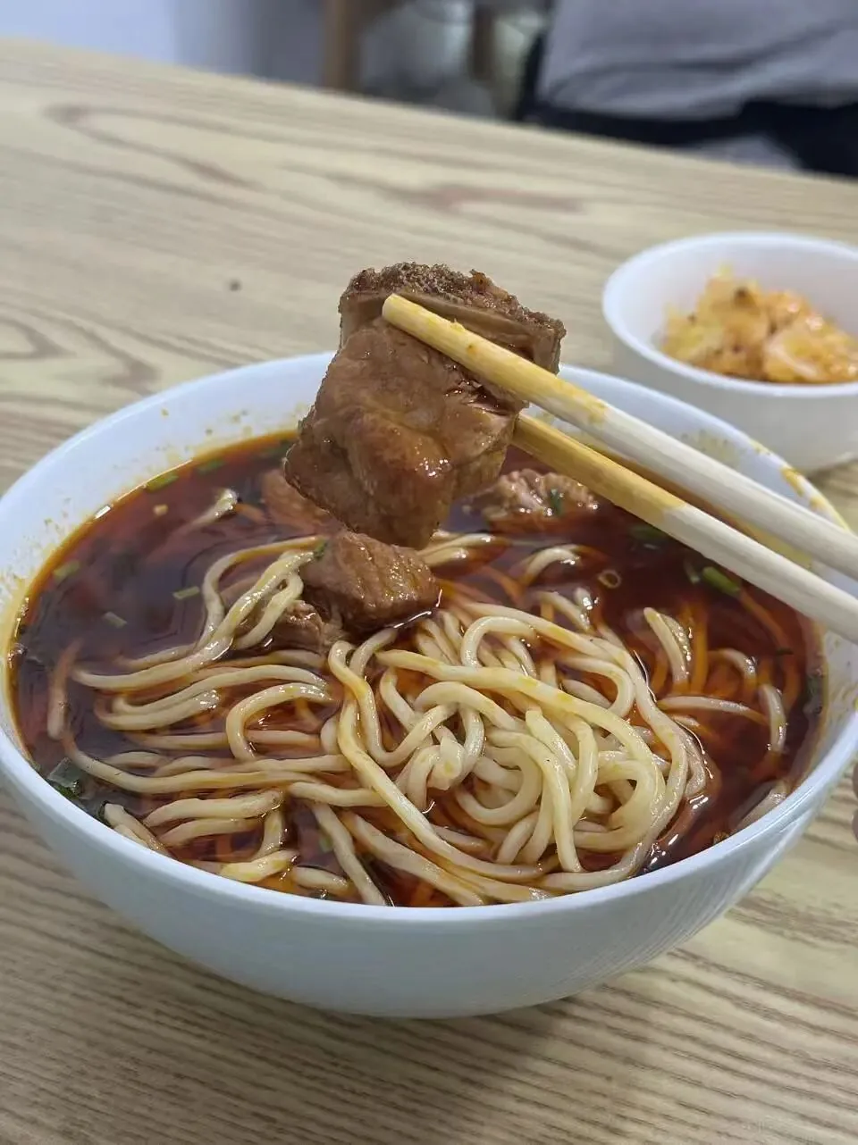 Heavy oil and rich pork rib broth in a bowl of Chengdu noodles